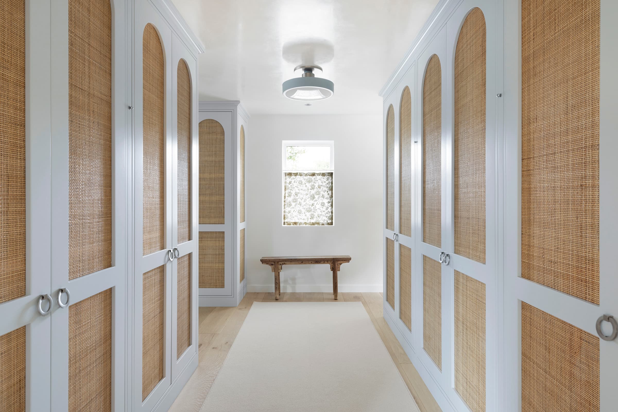 Luxury custom closet cabinetry and wardrobe systems: Cane Arched Closet Hallway 056